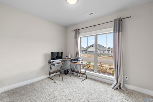 office space featuring a wealth of natural light, visible vents, baseboards, and carpet flooring