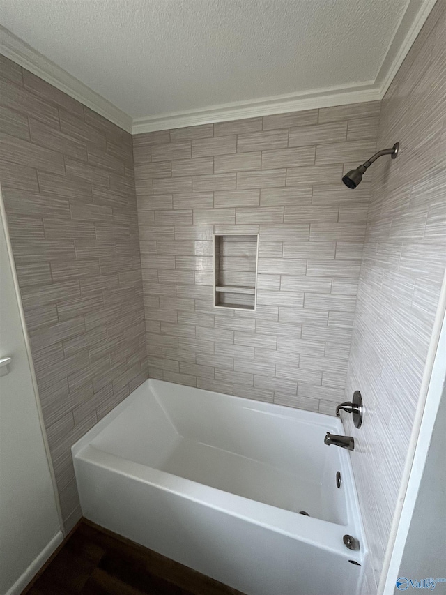 bathroom with tiled shower / bath and a textured ceiling