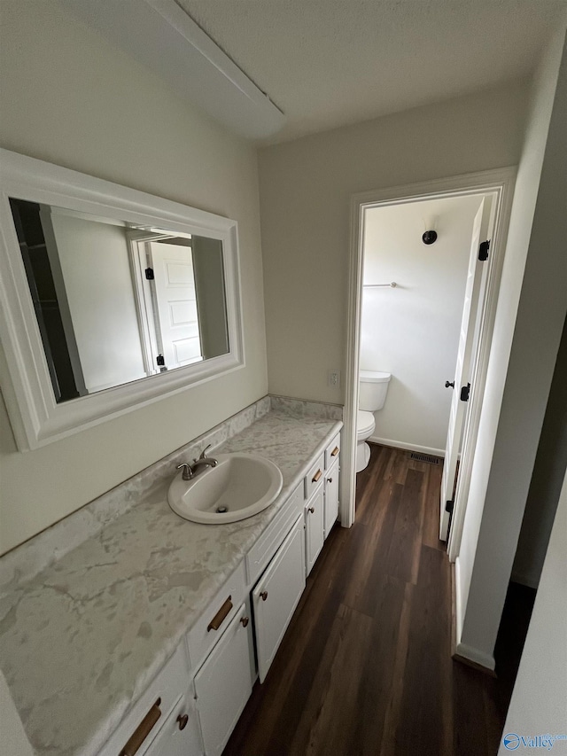 bathroom featuring hardwood / wood-style flooring, vanity, and toilet