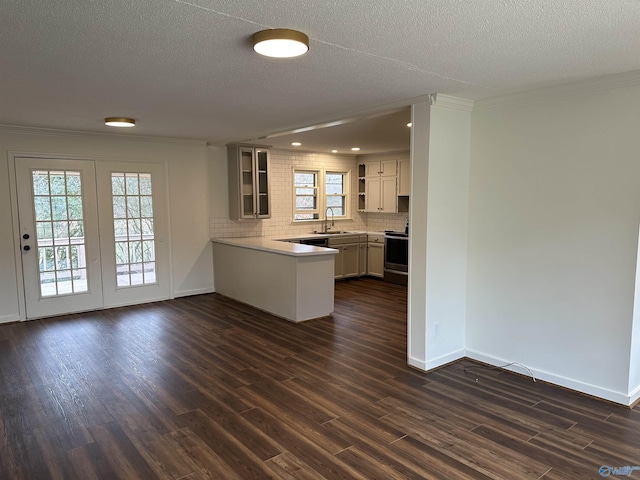 kitchen with sink, decorative backsplash, dark wood-type flooring, and kitchen peninsula