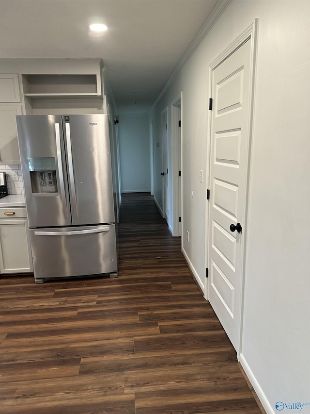 kitchen with crown molding, stainless steel fridge, tasteful backsplash, white cabinets, and dark hardwood / wood-style flooring