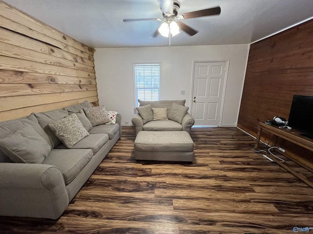 living room with wood finished floors, wood walls, and ceiling fan