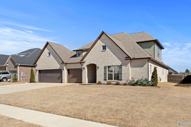 view of front of house with concrete driveway, brick siding, a shingled roof, and fence