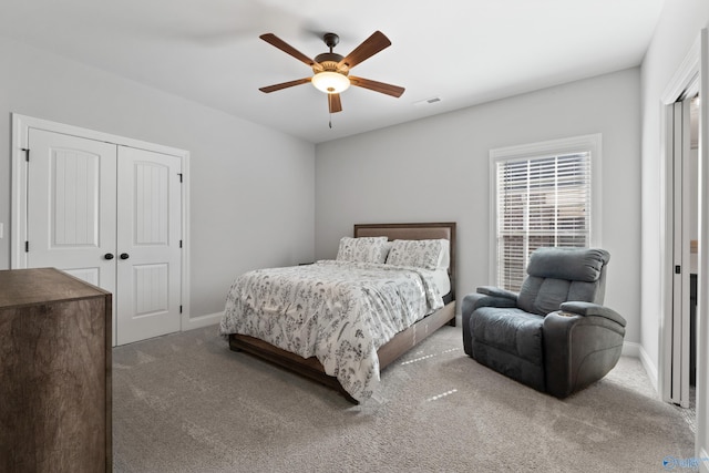 carpeted bedroom featuring a ceiling fan, a closet, visible vents, and baseboards