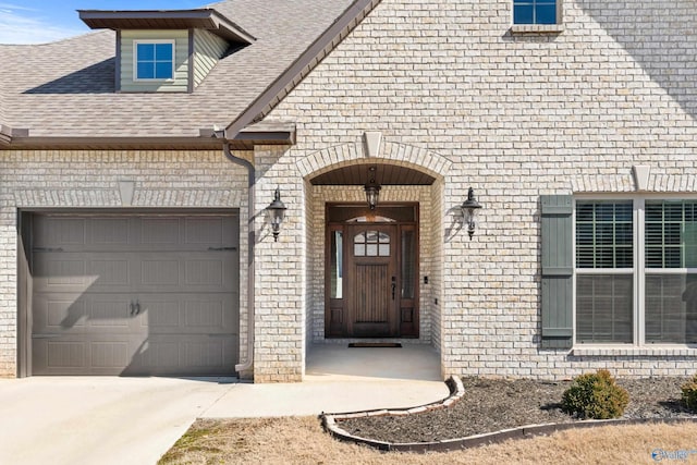 property entrance featuring a garage, brick siding, concrete driveway, and roof with shingles