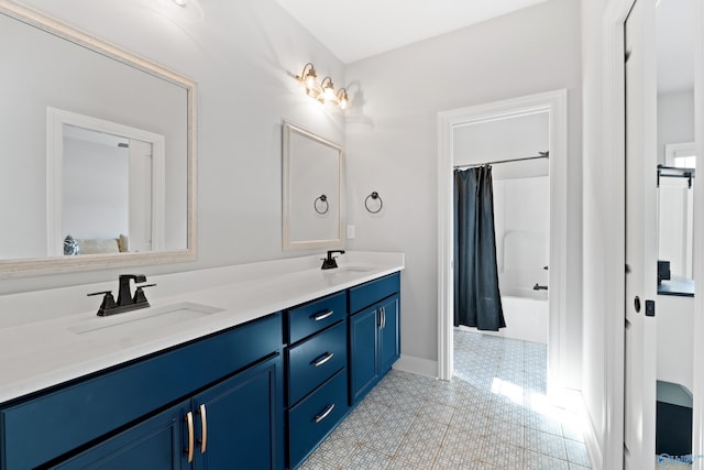 bathroom featuring baseboards, double vanity, a sink, and shower / tub combo with curtain