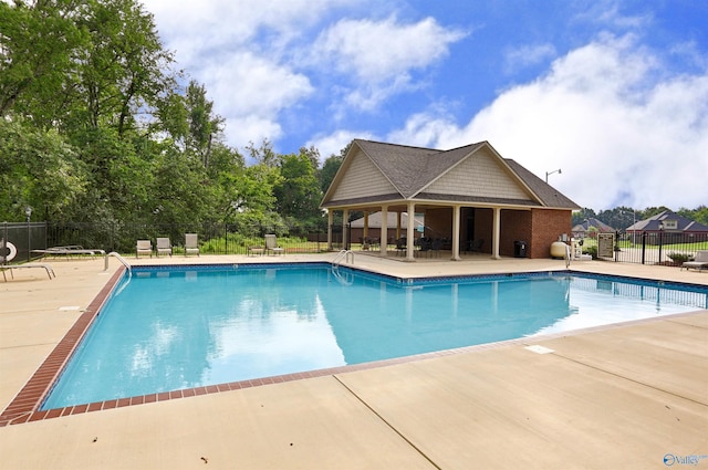 community pool with fence and a patio