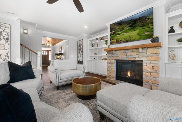 living area with built in shelves, ornamental molding, and wood finished floors