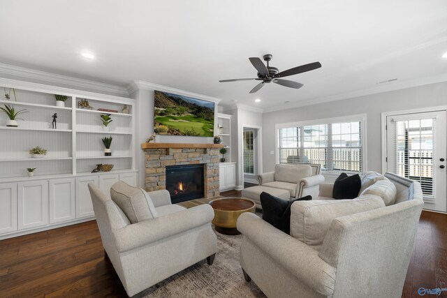 living area featuring dark wood finished floors, a ceiling fan, ornamental molding, a stone fireplace, and recessed lighting