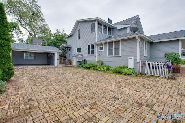 717 NE Eustis Ave, Huntsville, AL 35801 - rear view of house with fence, a gate, a chimney, and roof with shingles