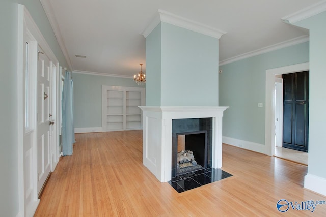 717 NE Eustis Ave, Huntsville, AL 35801 - unfurnished living room with wood finished floors, a chandelier, built in features, a fireplace, and ornamental molding