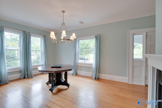 717 NE Eustis Ave, Huntsville, AL 35801 - dining room featuring a chandelier, light wood-style flooring, crown molding, and baseboards