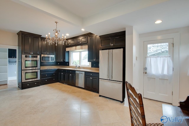 717 NE Eustis Ave, Huntsville, AL 35801 - kitchen with appliances with stainless steel finishes, a chandelier, a sink, light tile patterned floors, and recessed lighting