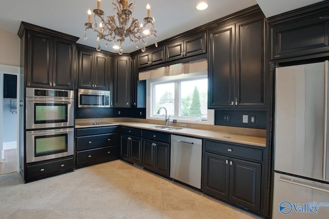 717 NE Eustis Ave, Huntsville, AL 35801 - kitchen featuring appliances with stainless steel finishes, a sink, a chandelier, light countertops, and light tile patterned flooring