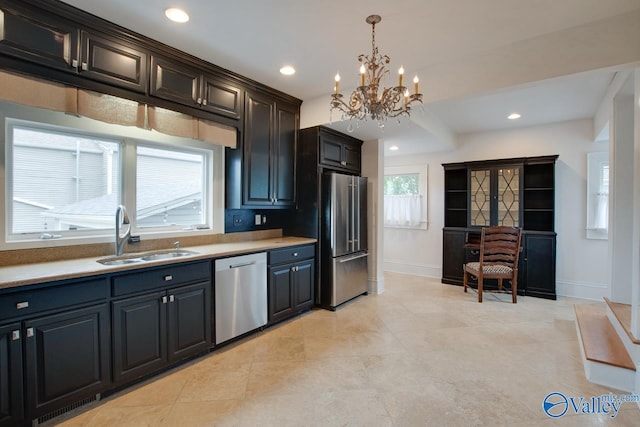 717 NE Eustis Ave, Huntsville, AL 35801 - kitchen with stainless steel appliances, a sink, a chandelier, baseboards, and hanging light fixtures