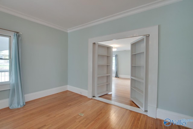 717 NE Eustis Ave, Huntsville, AL 35801 - empty room with healthy amount of natural light, wood finished floors, crown molding, and baseboards
