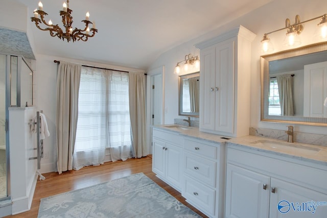 717 NE Eustis Ave, Huntsville, AL 35801 - full bathroom with wood finished floors, a chandelier, double vanity, and lofted ceiling