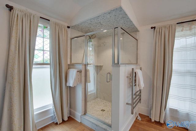 717 NE Eustis Ave, Huntsville, AL 35801 - bathroom with lofted ceiling, a stall shower, wood finished floors, and baseboards