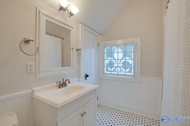 717 NE Eustis Ave, Huntsville, AL 35801 - full bathroom featuring wainscoting, vaulted ceiling, and vanity