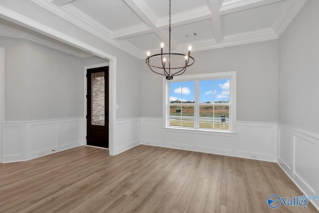 unfurnished dining area featuring visible vents, coffered ceiling, an inviting chandelier, light wood-type flooring, and beam ceiling