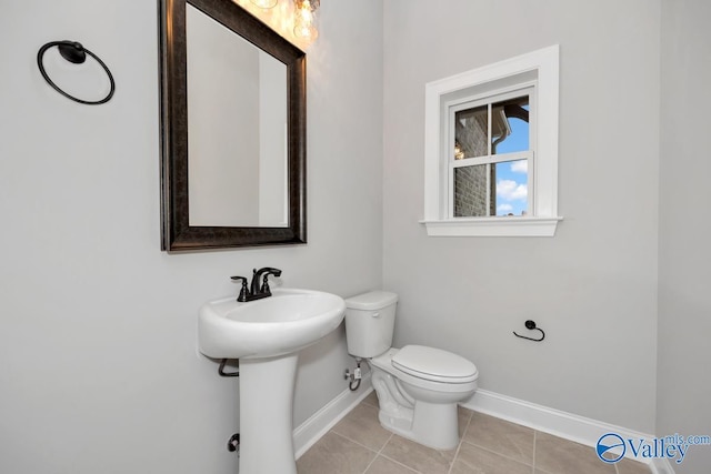 bathroom with tile patterned flooring, a sink, toilet, and baseboards