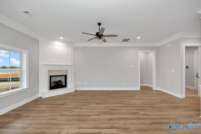 unfurnished living room featuring visible vents, crown molding, and baseboards