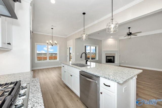 kitchen with stainless steel dishwasher, open floor plan, white cabinetry, a sink, and an island with sink