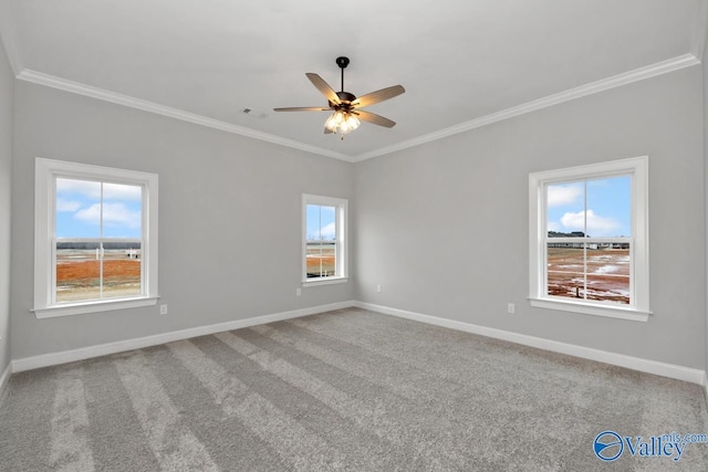 unfurnished room featuring carpet floors, ceiling fan, baseboards, and crown molding