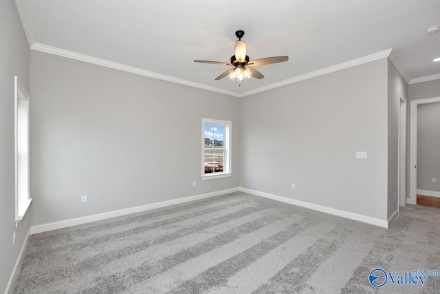 empty room with ceiling fan, baseboards, crown molding, and light colored carpet