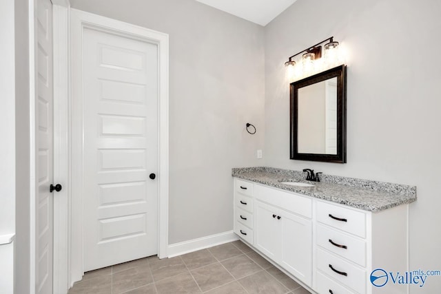 bathroom with vanity, baseboards, and tile patterned floors