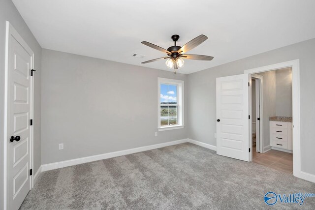 unfurnished bedroom with baseboards, ceiling fan, visible vents, and light colored carpet