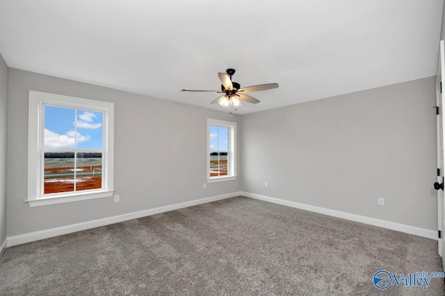 carpeted empty room featuring a ceiling fan and baseboards