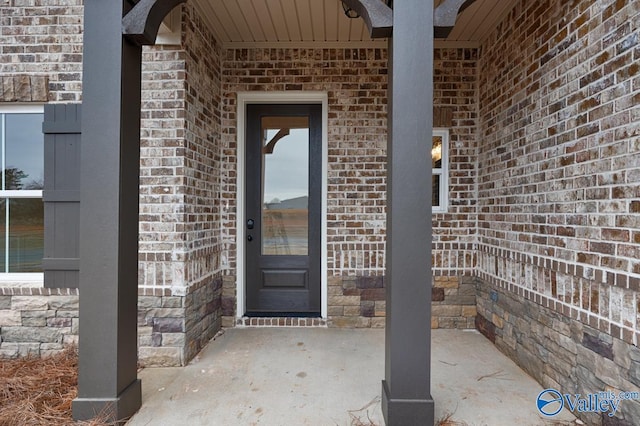 property entrance featuring a patio area and brick siding