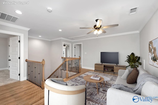 living area featuring ornamental molding, visible vents, and a ceiling fan