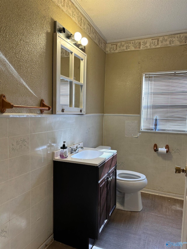 bathroom featuring vanity, a textured ceiling, toilet, and tile walls