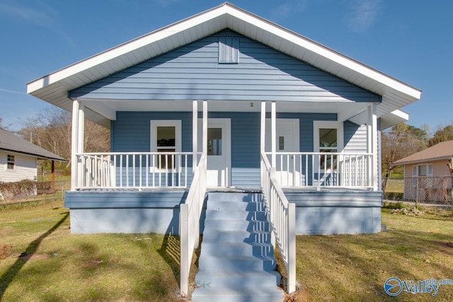 bungalow-style house with a porch, stairs, and a front lawn