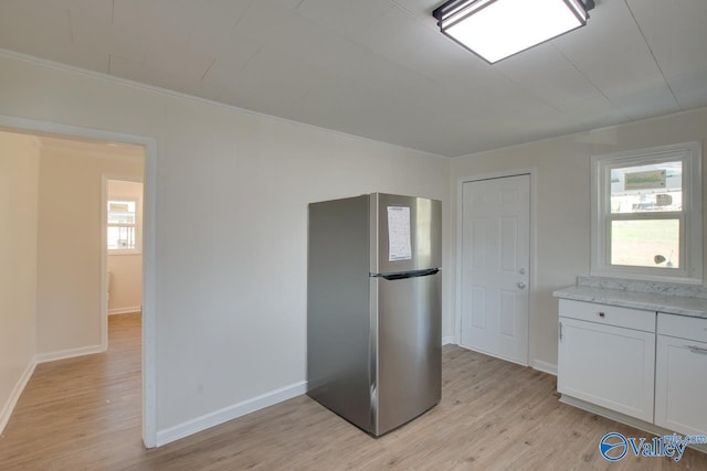 kitchen with light wood finished floors, a healthy amount of sunlight, and freestanding refrigerator