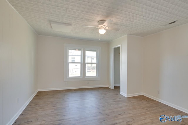 unfurnished room featuring a ceiling fan, visible vents, crown molding, and wood finished floors