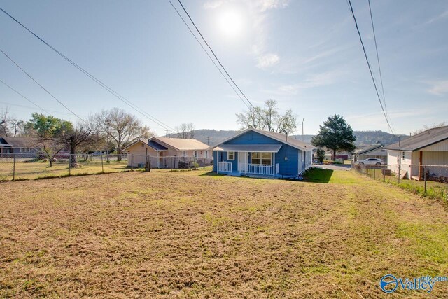 exterior space with covered porch, fence, and a front lawn