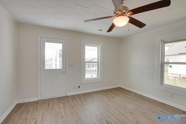 interior space with baseboards, light wood-type flooring, crown molding, and a ceiling fan