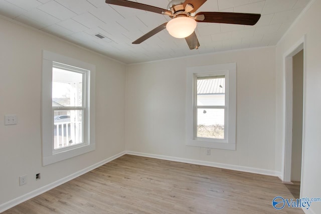 spare room featuring a ceiling fan, ornamental molding, baseboards, and light wood finished floors