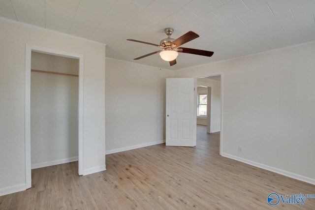 unfurnished bedroom with baseboards, crown molding, wood finished floors, and ceiling fan