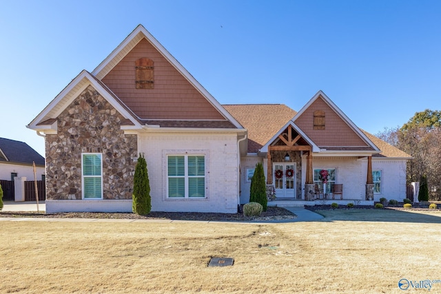 craftsman-style home featuring a front lawn and french doors