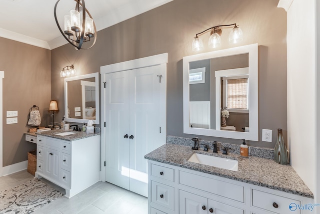 bathroom with vanity, ornamental molding, and a notable chandelier