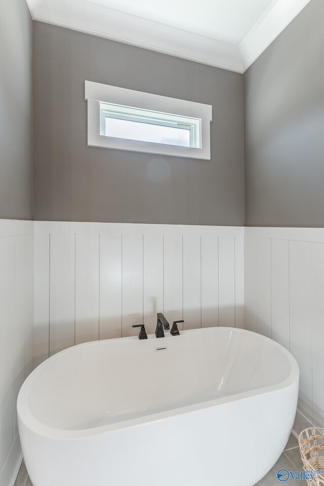 bathroom featuring tile patterned flooring, sink, ornamental molding, and a tub to relax in