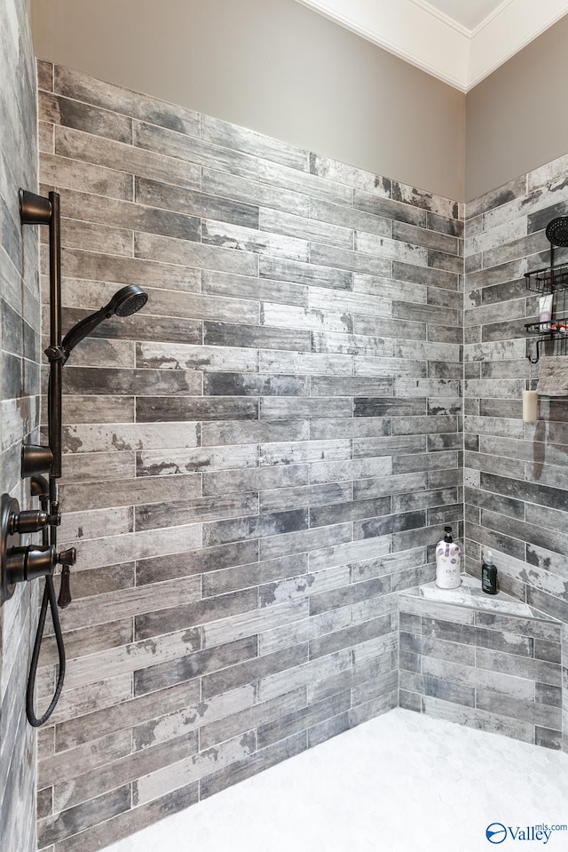 bathroom featuring crown molding and tiled shower