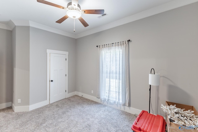 interior space with ceiling fan, crown molding, and light colored carpet