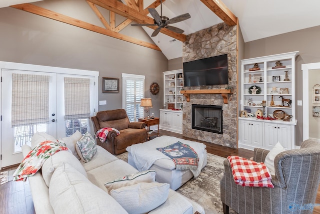 living room featuring ceiling fan, french doors, a stone fireplace, high vaulted ceiling, and wood-type flooring