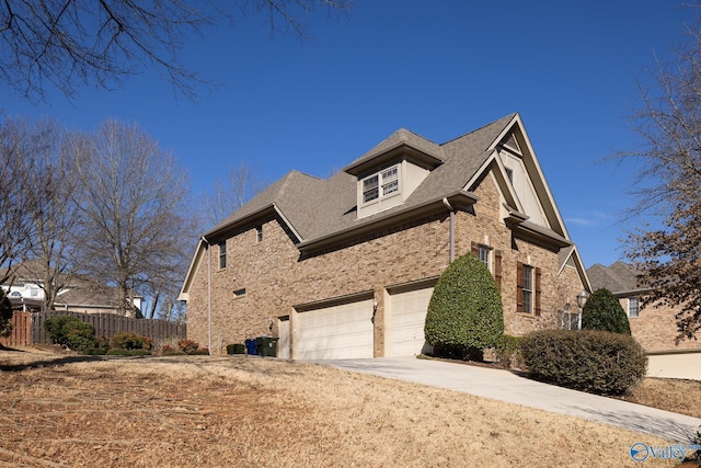 view of side of home with an attached garage, fence, concrete driveway, and brick siding