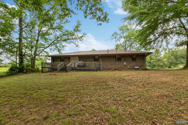 rear view of property featuring a yard and a deck